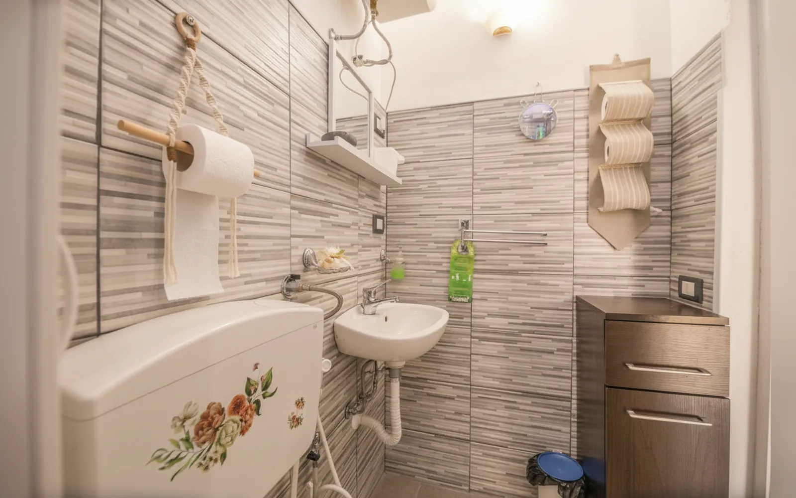 Il lavabo e la cassetta del WC decorata a fiori, nel bagno
