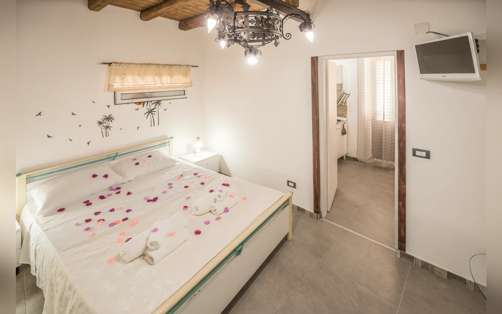 La camera vista dall’angolo, con il letto matrimoniale e la porta verso il resto della casa