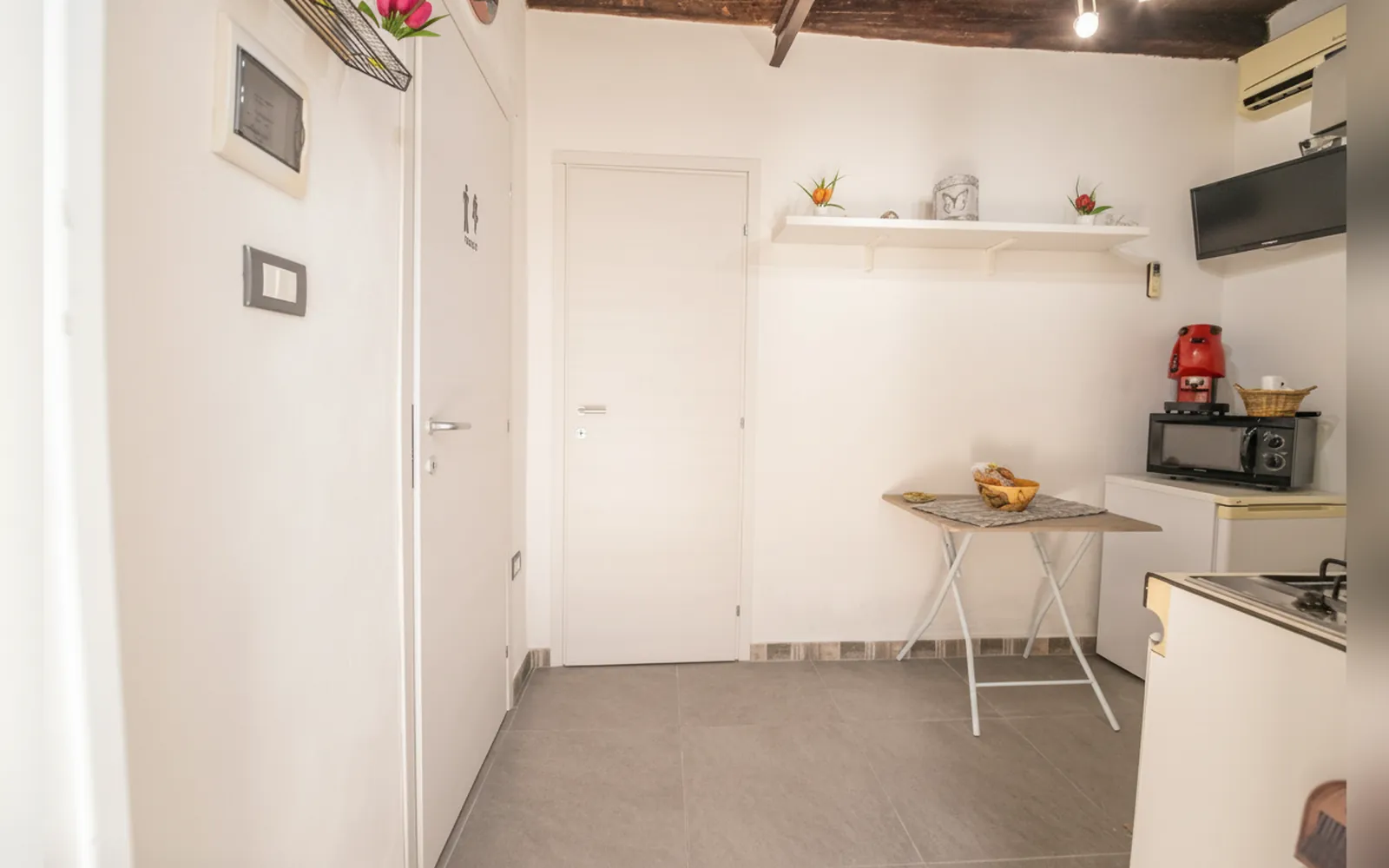 La zona cucina con il microonde, la macchina da caffè e il tavolino pieghevole