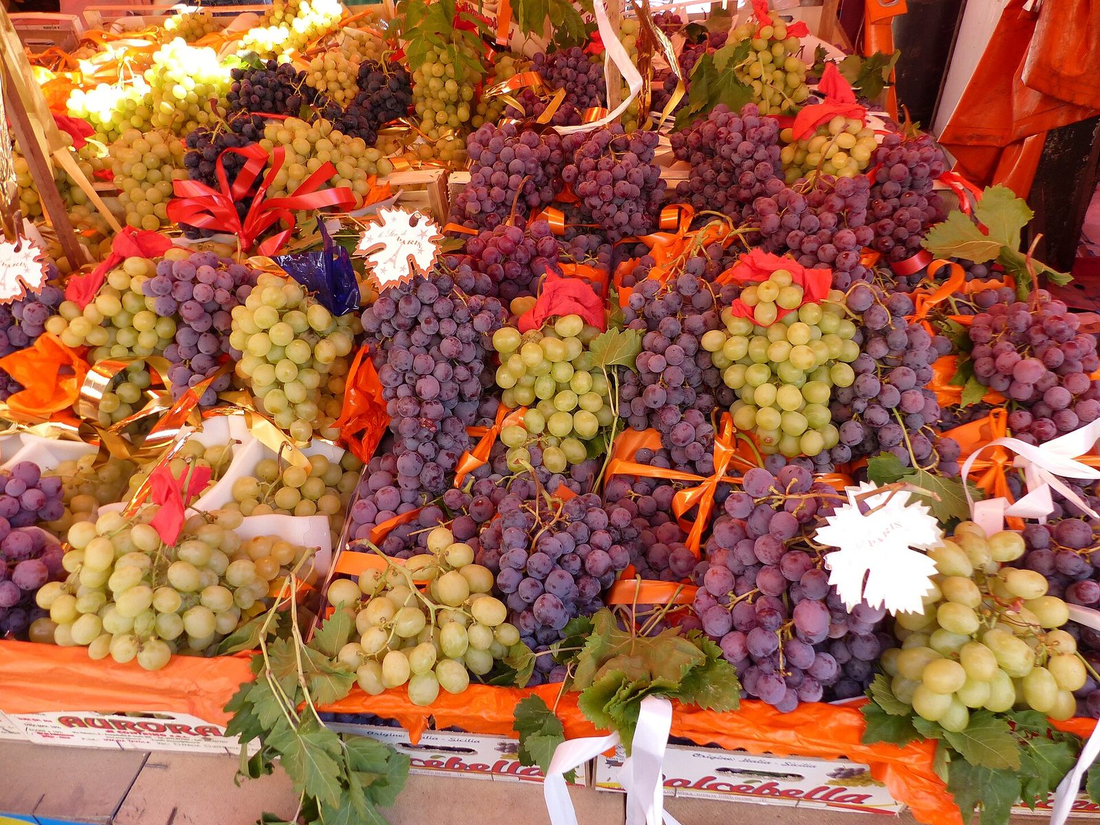 Un banco del mercato di Ballarò a Palermo carico di grappoli d'uva bianca e nera decorati con nastri colorati