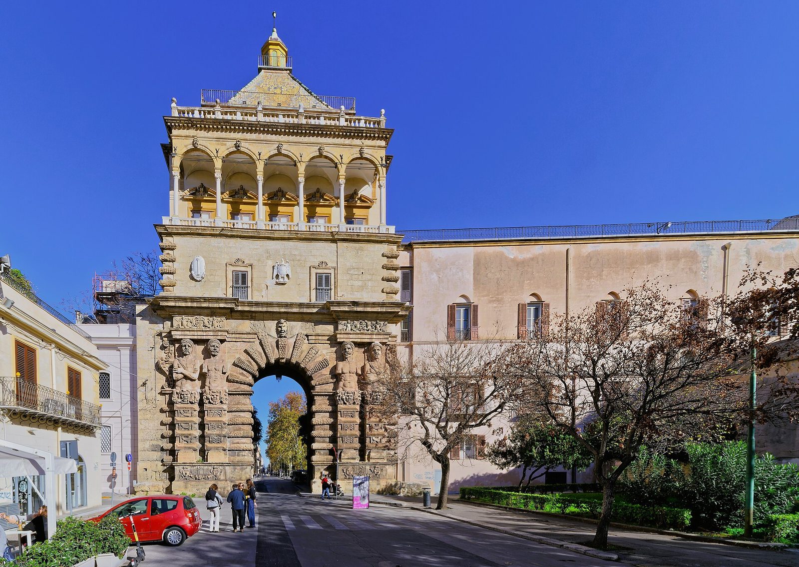 Porta Nuova a Palermo con la loggia, la cupola piramidale in maiolica e i telamoni sotto un cielo blu intenso