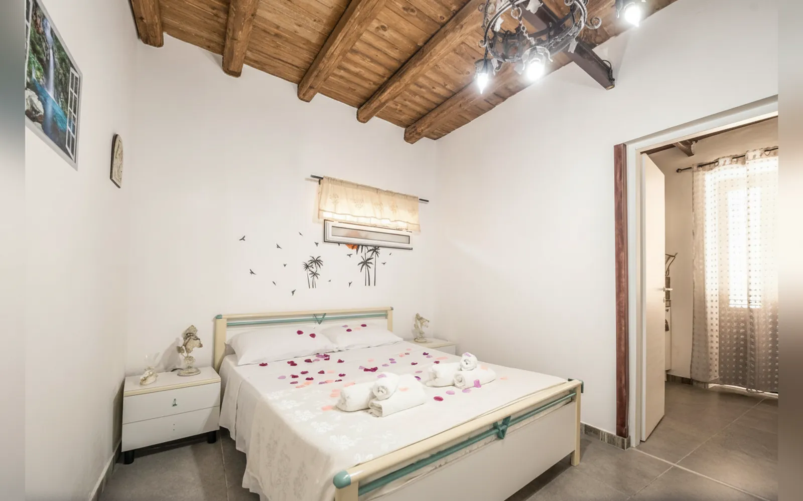 La camera con il letto matrimoniale e il soffitto con le travi in legno